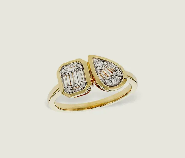 Elegant gold ring featuring two unique diamond shapes: an emerald cut and a pear shape.