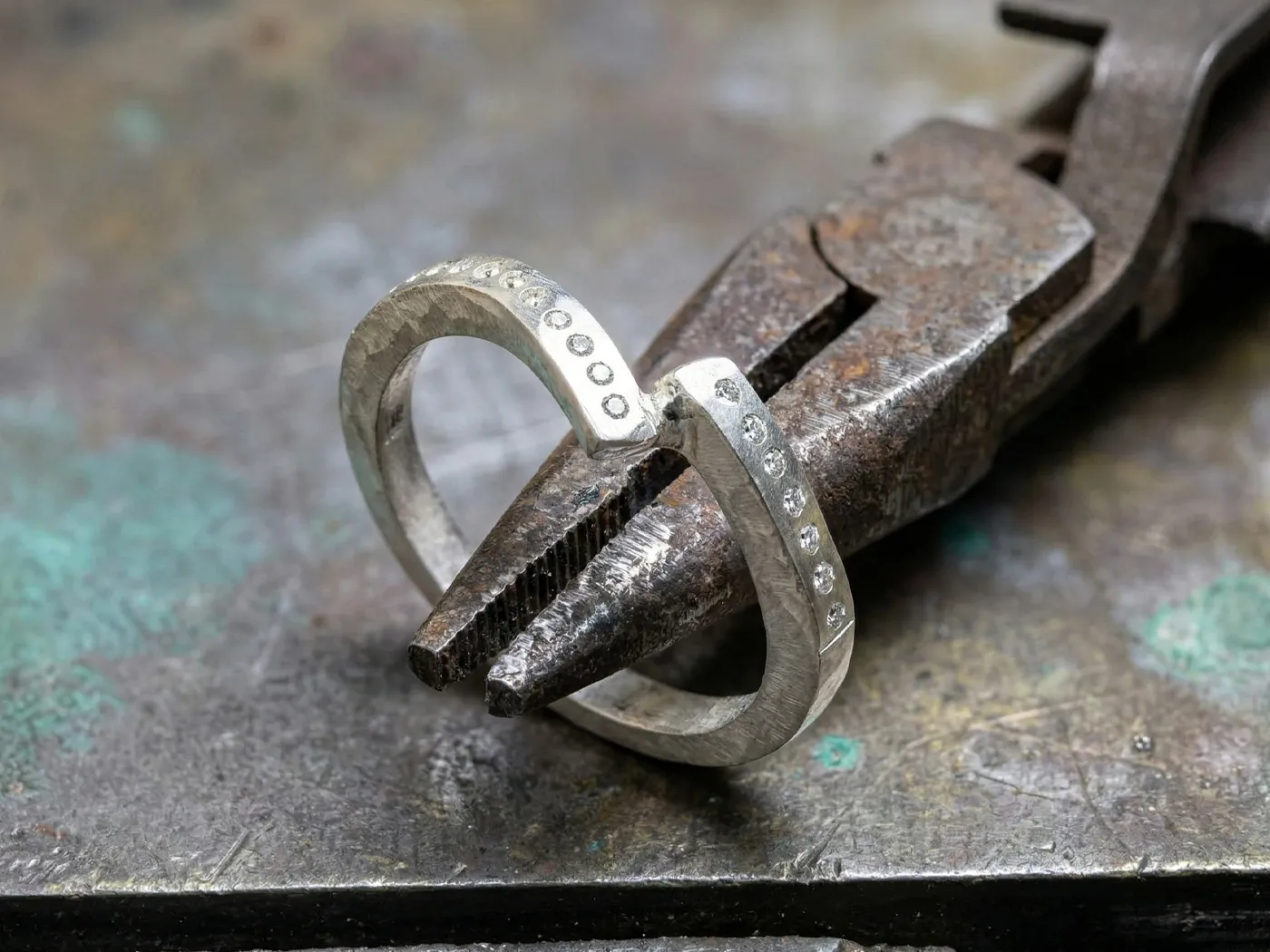 Diamond-studded ring on pliers, showcasing craftsmanship.