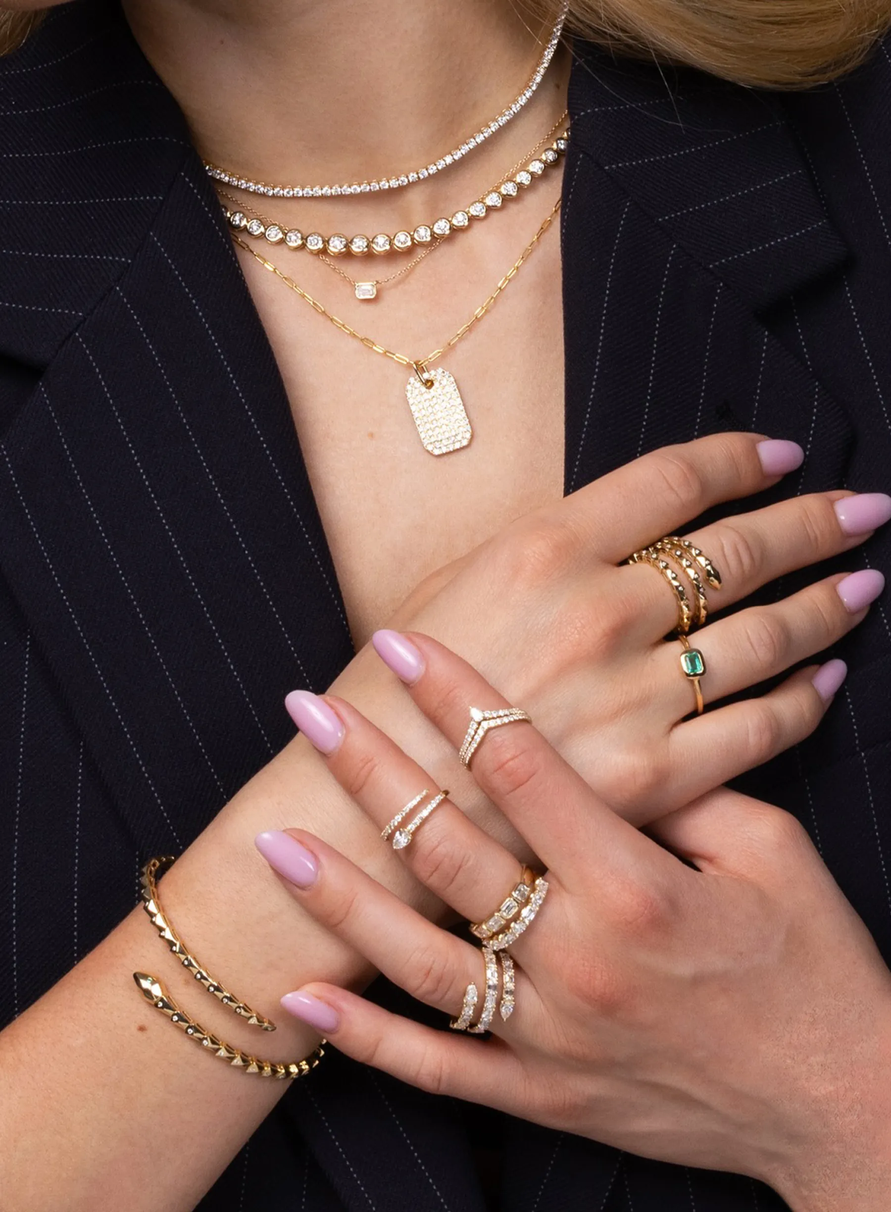 A picture of a neckline with jewelry and a hand with multiple rings