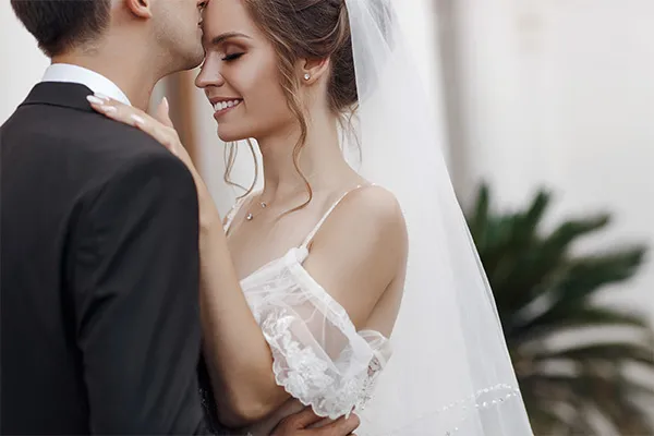 Bride and groom sharing a tender moment on their wedding day, showcasing love and joy. Click to explore more.