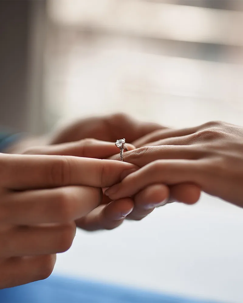 A large diamond ring with a halo of smaller diamonds on a textured background.