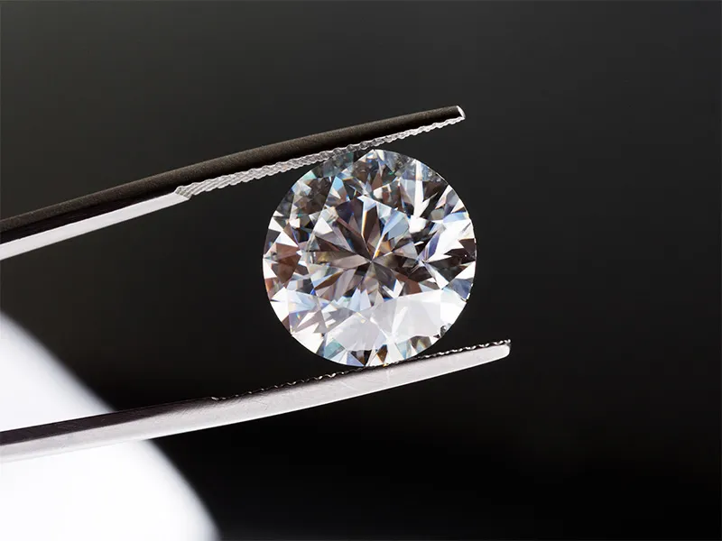 Lab grown diamond held in tweezers