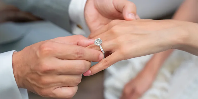 Close-up of a hand wearing a diamond ring.
