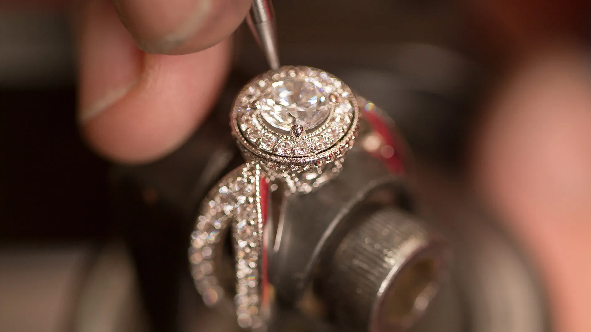 Jeweler crafting a ring in a workshop, showcasing fine jewelry craftsmanship at Quest Fine Jewelers in Fairfax.