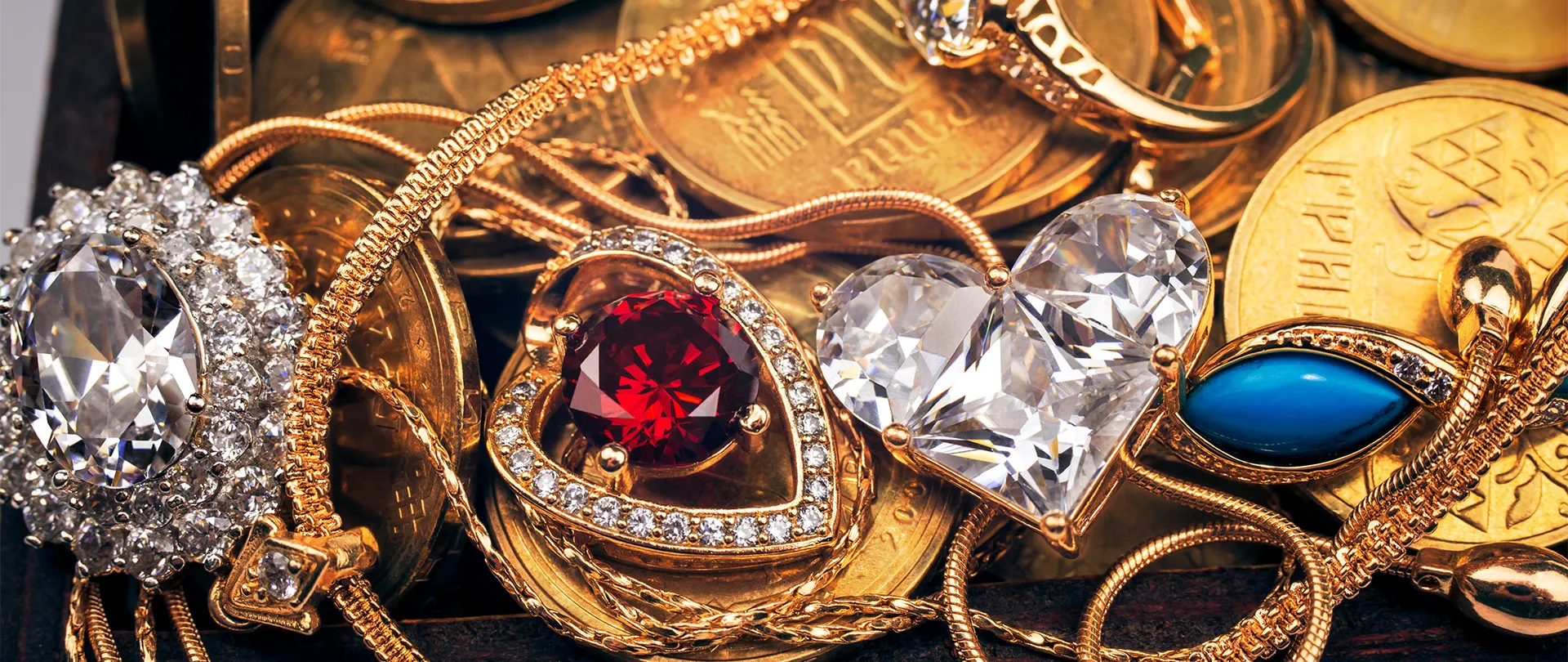 A collection of gold jewelry with gemstones and coins.