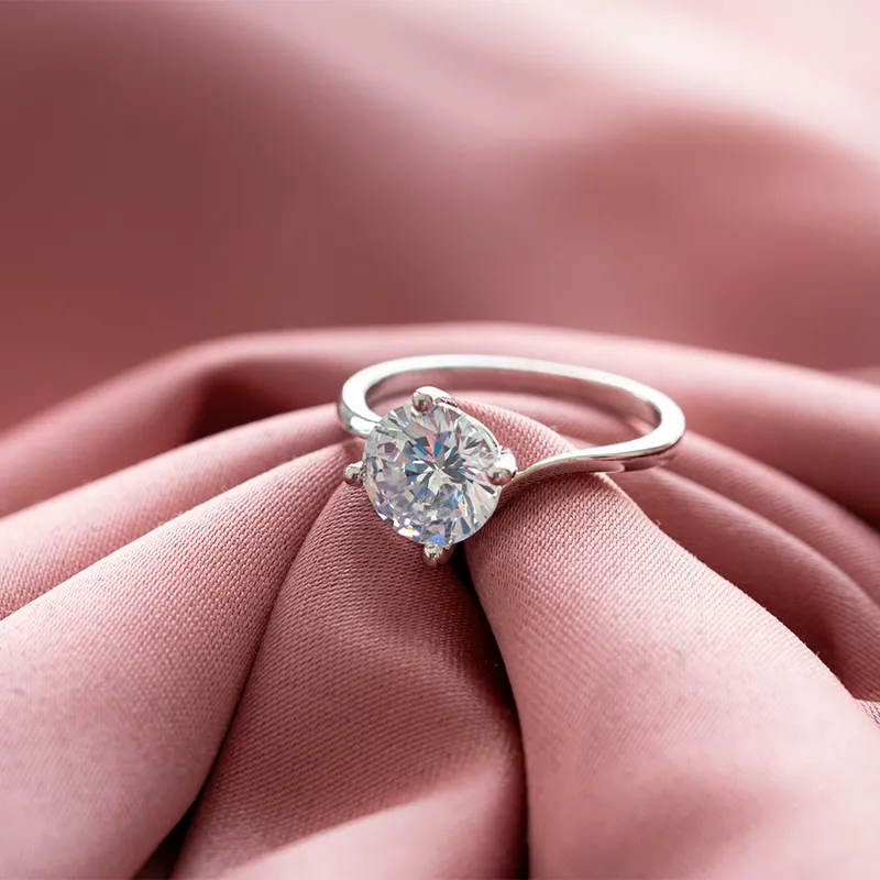 Close-up of a sparkling diamond engagement ring held between fingers. Click to explore more at Barthau Jewellers.