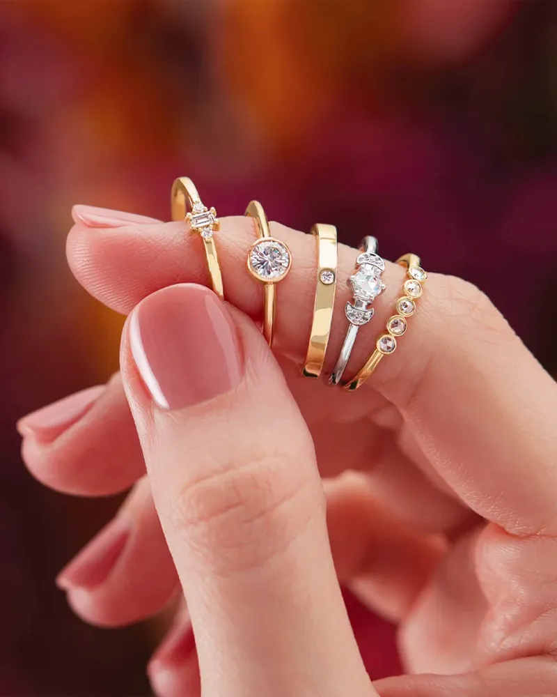 Two hands wearing rose gold rings, one with an emerald-cut diamond engagement ring, showcasing love and commitment.